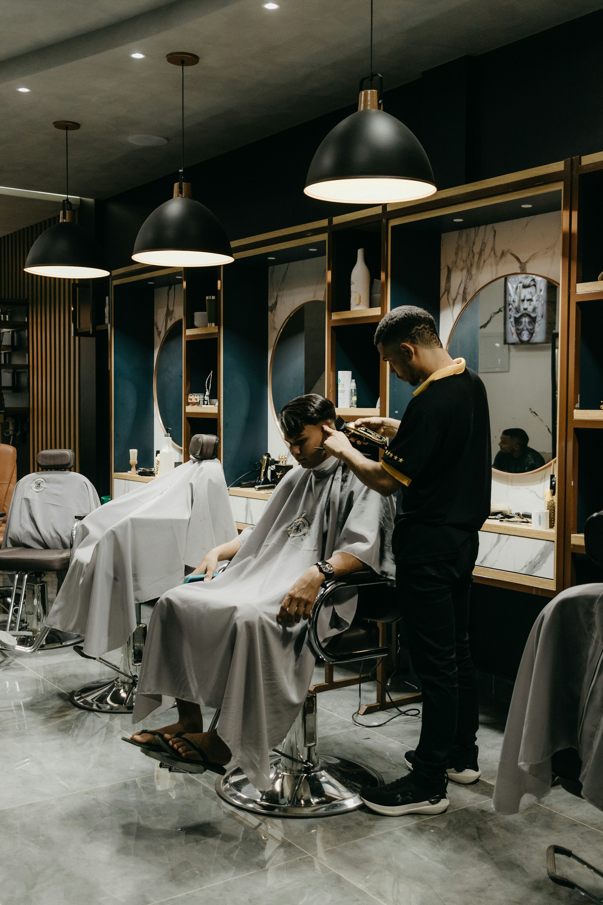 Barber muda memotong rambut klien di studio modern